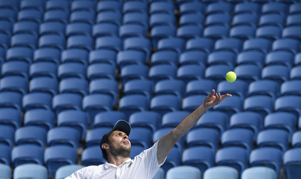 Russia's Aslan Karatsev serves to Canada's Felix Auger-Aliassime during their fourth round match at the Australian Open tennis championships in Melbourne, Australia, Sunday, Feb. 14, 2021. The Australian Open continues but without crowds after the Victoria state government imposed a five-day lockdown in response to a COVID-19 outbreak at a quarantine hotel. (AP Photo/Andy Brownbill)