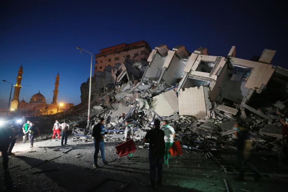 People mill about a collapsed building