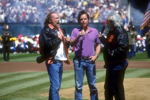 Grateful Dead band members Vince Welnick, Bob Weir, and Jerry Garcia (L-R) sing the national anthem in 1993.