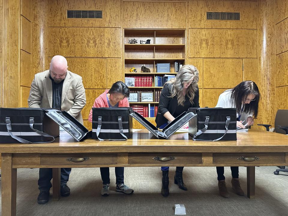 Employees of the North Dakota Secretary of State's Office unbox and count petitions for a ballot initiative to set an age limit for North Dakota congressional candidates, Friday, Feb. 9, 2024, at the state Capitol in Bismarck, N.D. The office has until March 15 to review the signatures. The measure would appear on North Dakota's June ballot. (AP Photo/Jack Dura)