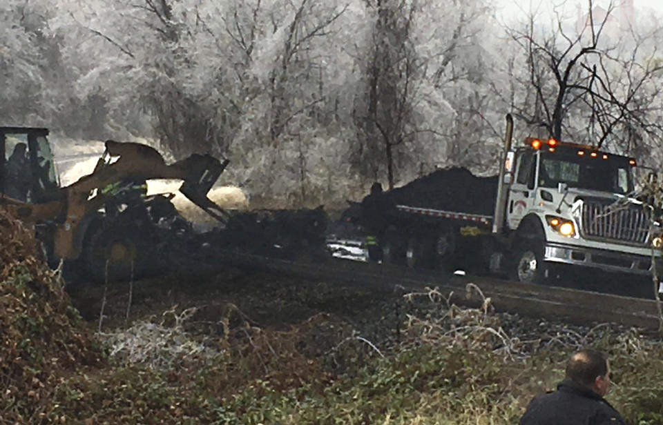 Authorities clean up the remains of a tanker truck the slid off Interstate 95 in Baltimore, Md., on Saturday morning, Dec. 17, 2016, following an overnight ice storm. (Karl Merton Ferron/The Baltimore Sun via AP)