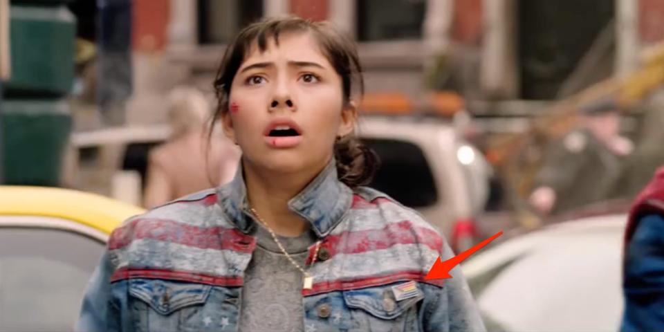 A red arrow pointing to an LGBTQ+ pin worn by America Chavez in "Doctor Strange in the Multiverse of Madness."