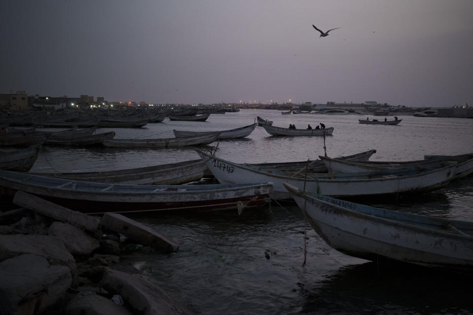 Traditional Mauritanian fishing boats known as pirogues are moored at the port in Nouadhibou, Mauritania, Wednesday, Dec. 1, 2021. (AP Photo/Felipe Dana)