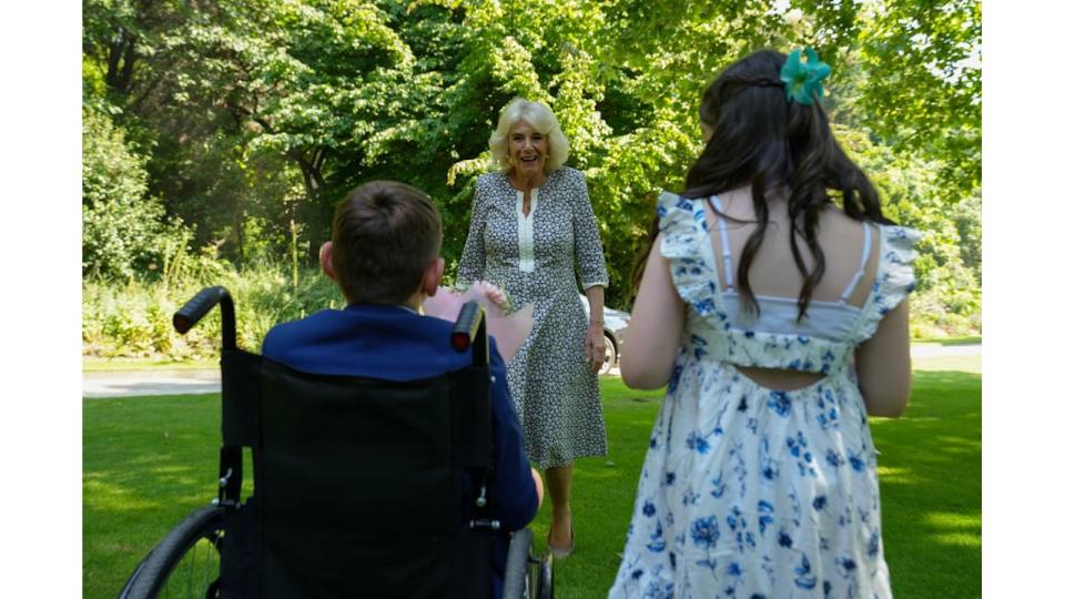 Queen Camilla greeting a young girl and a young boy in a wheelchair