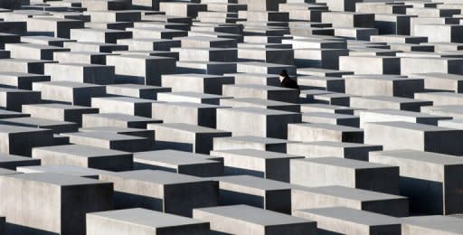 A man walks past concrete steles of the Monument for the Murdered Jews of Europe in Berlin in January. Residents of one Berlin apartment building have tracked down the names and fates of the Jewish people who once lived there and put up a plaque to remember them individually