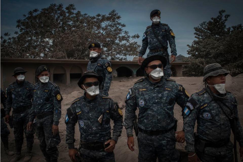 Rescue workers, clad in masks to protect them from the air, in the ruins of San Miguel Los Lotes on June 5.