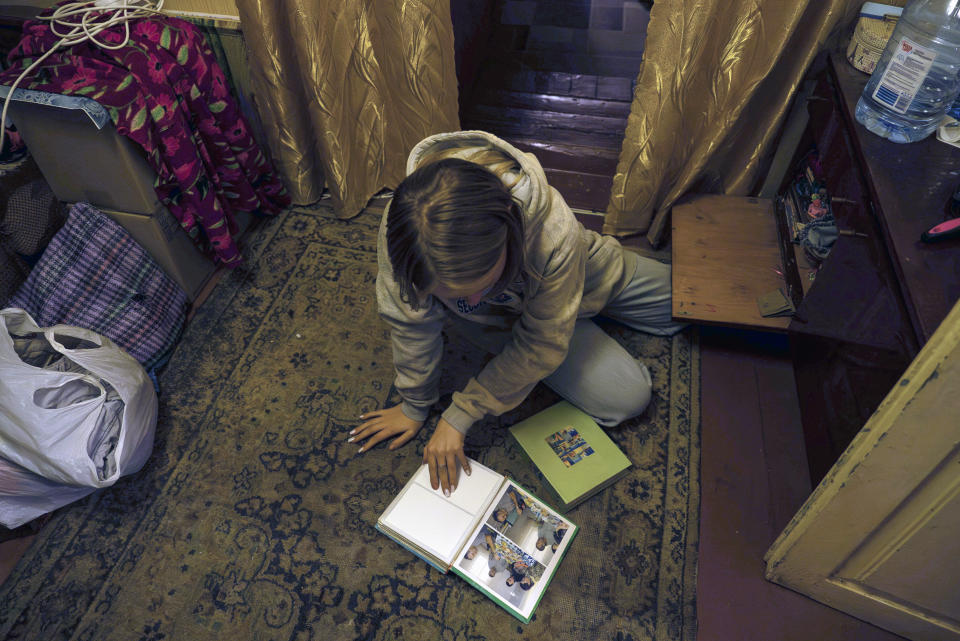 15-year-old Ksiusha Mukhovata shows pictures of her family in the village of Hroza near Kharkiv, Ukraine, Friday, Oct. 6, 2023. Her parents were killed as the Russian rocket hit a village store and cafe in one of the deadliest attacks in recent months, killing at least 51 civilians. (AP Photo/Alex Babenko)