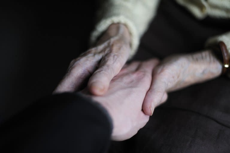 File photo shows a woman suffering from Alzheimer's desease holding the hand of a relative at a retirement home in France. Technology capable of diagnosing Alzheimer's disease before its symptoms appear won a coveted honor for innovation at the South by Southwest festival