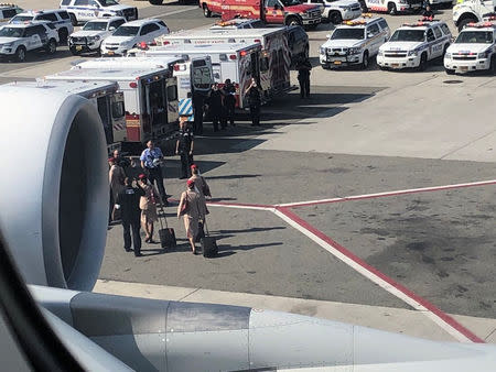 Air cabin crew members and the emergency services are seen leaving the plane, after the passengers were taken ill on a flight from New York to Dubai, on JFK Airport, New York, U.S., September 05, 2018 in this still image obtained from social media. Larry Coben/via REUTERS