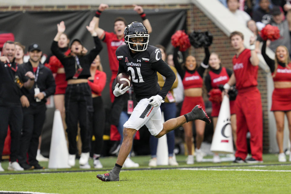 Cincinnati wide receiver Tyler Scott (21) scores during the first half of an NCAA college football game against Navy, Saturday, Nov. 5, 2022, in Cincinnati. (AP Photo/Jeff Dean)