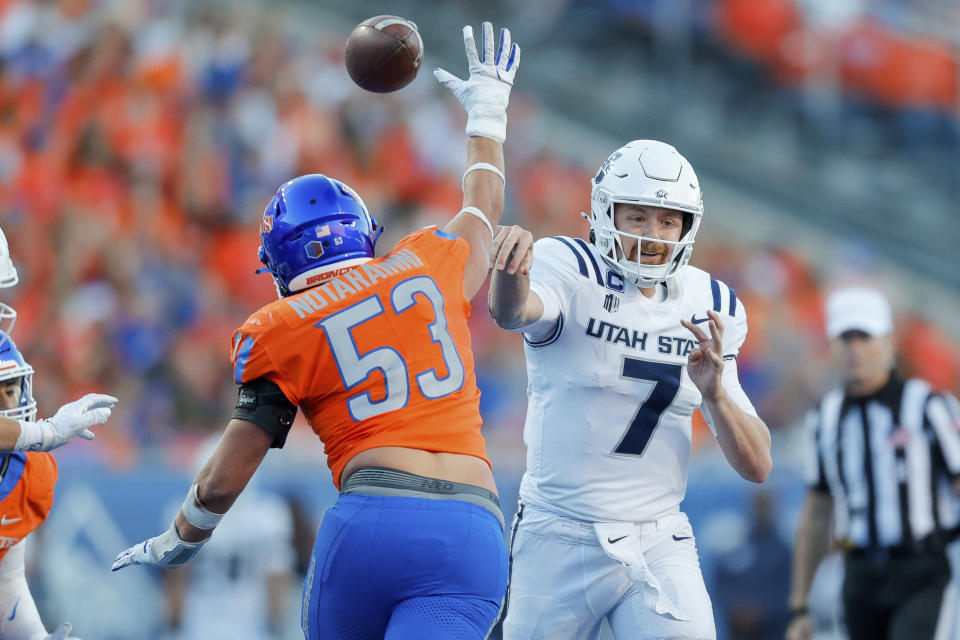 Utah State quarterback Spencer Petras (7) throws the ball under pressure from Boise State linebacker Marco Notarainni (53) in the first half of an NCAA college football game, Saturday, Oct. 5, 2024, in Boise, Idaho. . (AP Photo/Steve Conner)