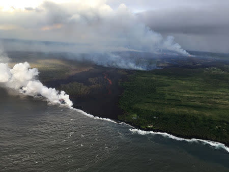 The fissure complex, pictured in the upper right, continues to feed a meandering lava flow (in the center). into the Pacific Ocean in southeast of Pahoa during ongoing eruptions of the Kilauea Volcano in Hawaii, U.S. May 22, 2018. Picture taken on May 22, 2018. USGS/Handout via REUTERS