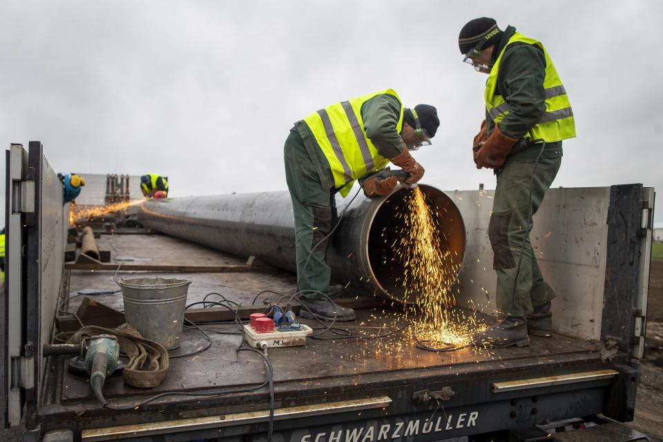 Employees work at the site of the damaged pipeline near Valakeliai village, outside Pasvalys, 175 km (109 miles) north of Vilnius in northern Lithuania on Saturday Jan. 14, 2023. A powerful gas pipeline explosion that prompted the evacuation of a village in northern Lithuania was most likely caused by a technical malfunction, the head of the country's natural gas transmission system said Saturday. The blast Friday evening sent flames 50 meters (about 150 feet) into the sky. (AP Photo/Mindaugas Kulbis)