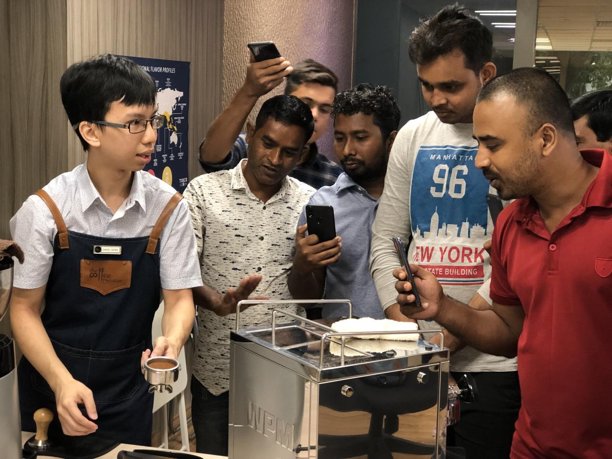 The Coffee Roaster founder Ang Swee Heng, 26, shows Bangladeshi migrant workers the ropes of brewing gourmet coffee. PHOTO: Nicholas Yong/Yahoo News Singapore