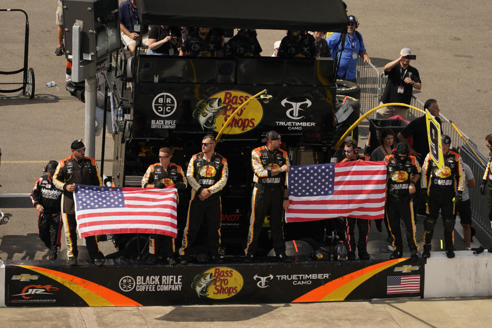 The pit crew of Noah Gragson (9) displays the U.S. flag during laps nine, ten and eleven during the NASCAR Xfinity auto race in Richmond, Va., Saturday, Sept. 11, 2021. (AP Photo/Steve Helber)