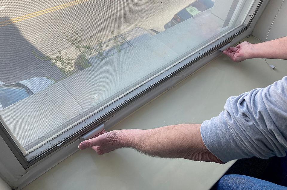 An Essex House resident tries to open their apartment window that does not open and the building's central air conditioning is not working on Wednesday.
