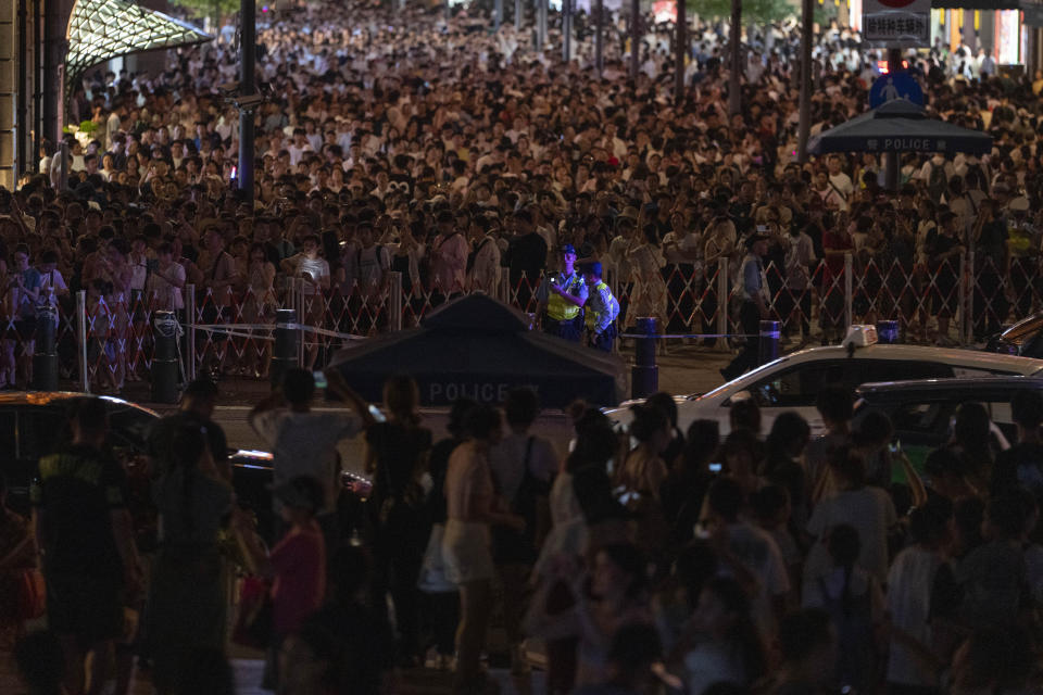 Chinese policemen monitor the crowd near the bund in Shanghai, Wednesday, July 31, 2024. (AP Photo/Ng Han Guan)