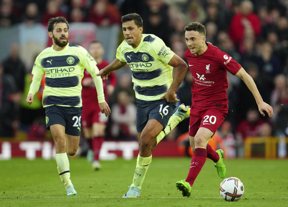 Liverpool's Diogo Jota, right, duels for the ball with Manchester City's Rodrigo during the English Premier League soccer match between Liverpool and Manchester City at Anfield stadium in Liverpool, Sunday, Oct. 16, 2022. (AP Photo/Jon Super)
