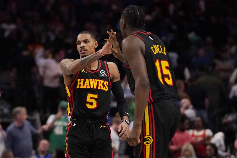 Atlanta Hawks guard Dejounte Murray (5) is congratulated by teammate Clint Capela (15) during the fourth quarter of an NBA basketball game against the Dallas Mavericks in Dallas, Wednesday, Jan. 18, 2023. Hawks won 130-122. (AP Photo/LM Otero)