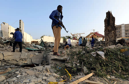 Security officers assess the stand at the scene after a suicide car explosion in front of Doorbin hotel in Mogadishu, Somalia February 24, 2018. REUTERS/Feisal Omar