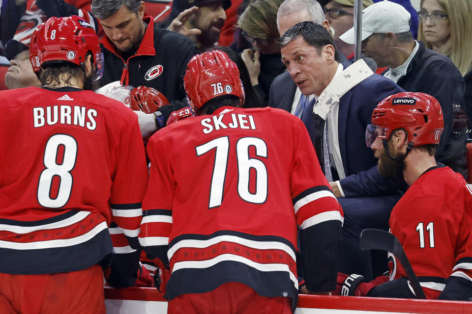 Carolina Hurricanes coach Rod Brind'Amour, back right, speaks to his players during a timeout during the third period of the team's NHL hockey game against the Vancouver Canucks in Raleigh, N.C., Tuesday, Feb. 6, 2024. (AP Photo/Karl B DeBlaker)