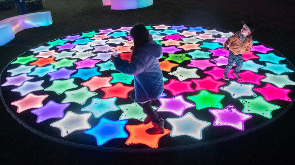 Children play on a circle of glowing stars that change color when stepped on. Hundreds of brightly colored, enchanted and whimsical lanterns greet visitors at a sneak peek opening of the Stockton Lantern Festival at the Stockton Ballpark in downtown Stockton on Nov. 20, 2023. The festival opens on Nov. 24 and runs through Jan. 5, 2024.