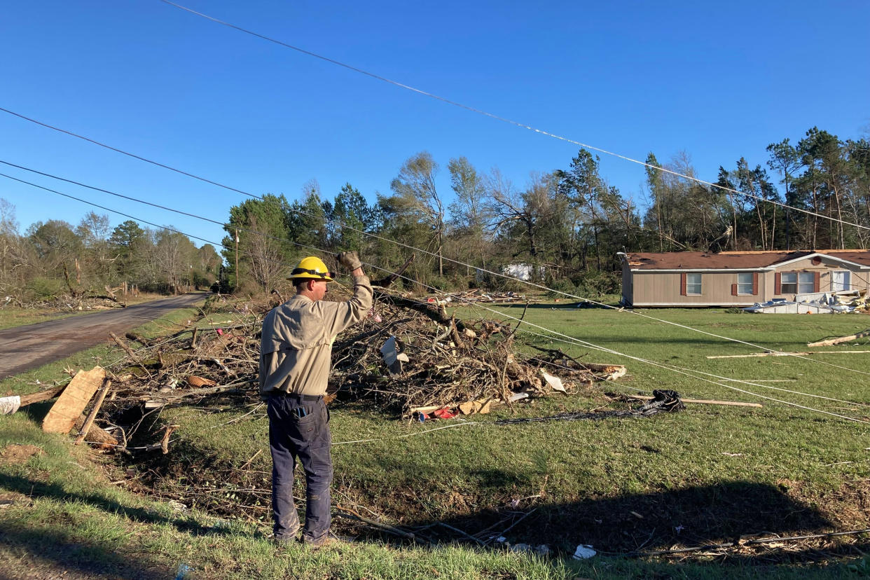 A utility worker checks lines following severe weather Wednesday, Dec. 14, 2022, in Keithville, La. A volatile storm ripping across the U.S. spawned tornadoes that killed a young boy and his mother in Louisiana, smashed mobile homes and chicken houses in Mississippi and threatened neighboring Southern states with more punishing weather Wednesday. (AP Photo/Jake Bleiberg)