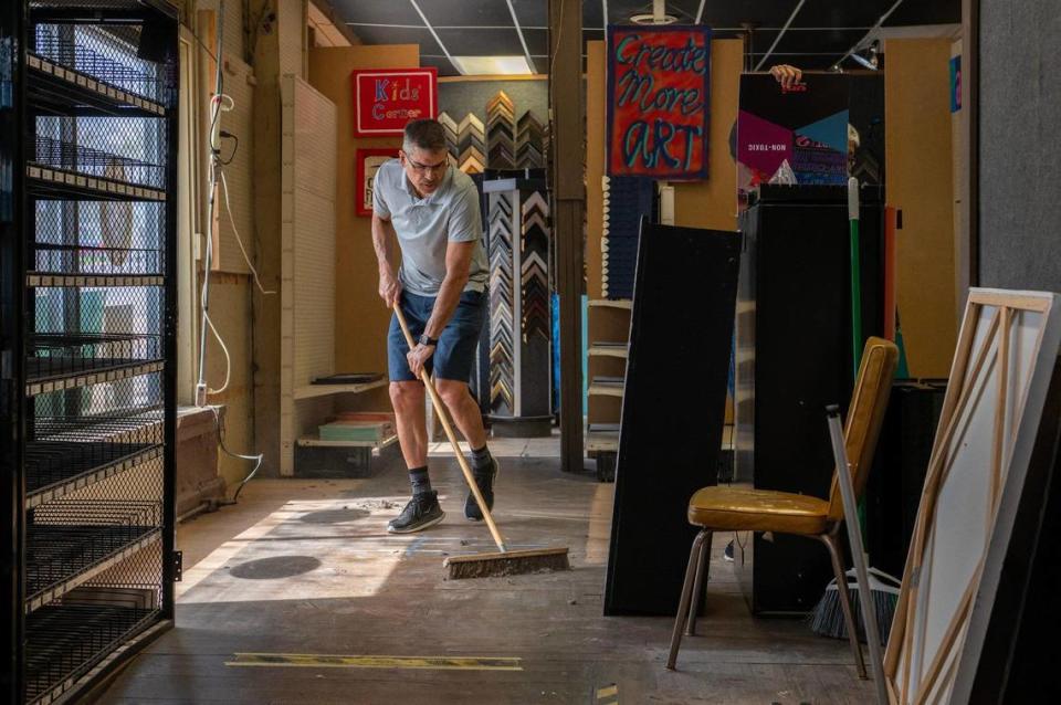 Greg McKean, co-owner of Creative-Coldsnow, sweeps dust off the floors at the Westport shop.