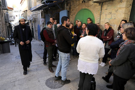 Tour guides, Noor Awad, a Palestinian from Bethlehem, and Lana Zilberman Soloway, a Jewish seminary student, speak to a group of tourists during the Dual Narrative tour they lead in Jerusalem's Old City February 4, 2019. REUTERS/Ammar Awad/Files