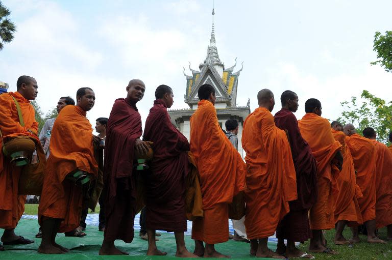 Cambodian Buddhist monks line up to receive donation at Choeung Ek killing fields memorial in Phnom Penh on April 17, 2015