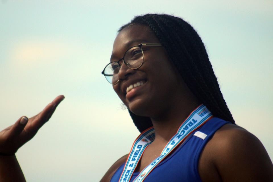 Zee Curtis of Bolles waves to the crowd after winning the Class 2A girls discus.