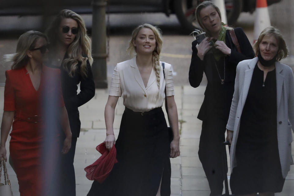Actress Amber Heard, center, arrives at the High Court in London, Monday, July 20, 2020. Amber Heard started Monday to give evidence at the High Court in London as part of Johnny Depp’s libel case against The Sun over allegations of domestic violence during the couple's relationship. (AP Photo/Matt Dunham)