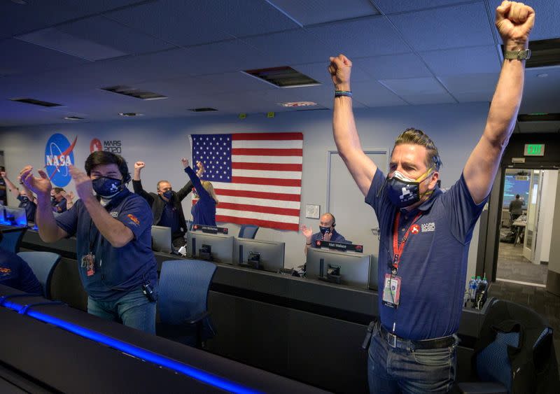 Members of NASA’s Perseverance rover team react in mission control after receiving confirmation the spacecraft successfully touched down on Mars