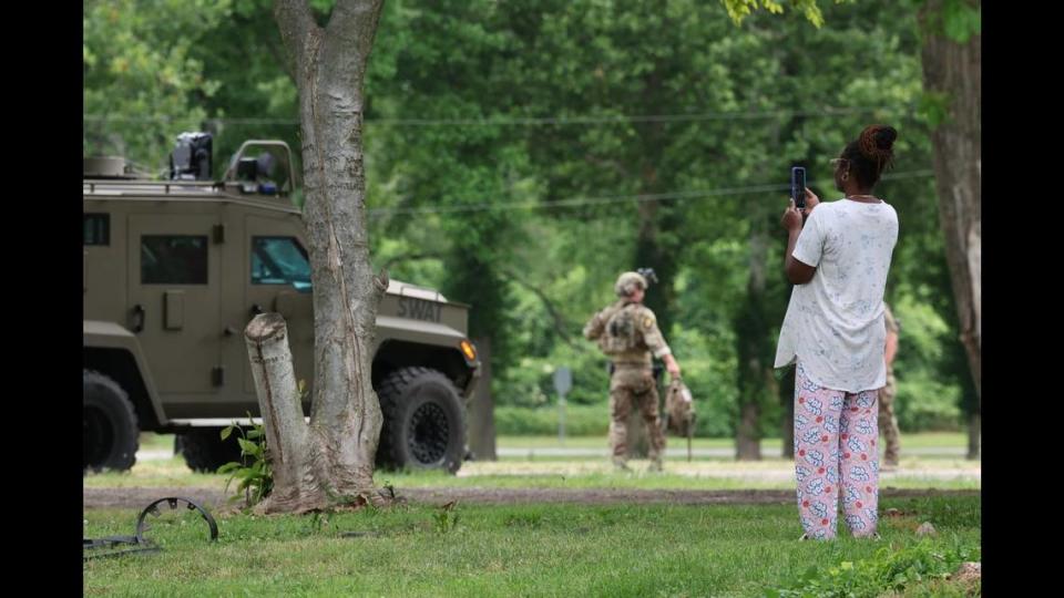 A neighbor films SWAT officers as they conduct operations at a house at 7127 Lake Drive in Cahokia Heights, Ill. On June 18, 2024.