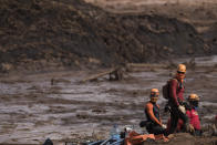 Firefighters looks on as they work on a site where a body as found inside as vehicle stuck in the mud, days after a dam collapse in Brumadinho, Brazil, Monday, Jan. 28, 2019. Firefighters on Monday carefully moved over treacherous mud, sometimes walking, sometimes crawling, in search of survivors or bodies four days after a dam collapse that buried mine buildings and surrounding neighborhoods with iron ore waste. (AP Photo/Leo Correa)