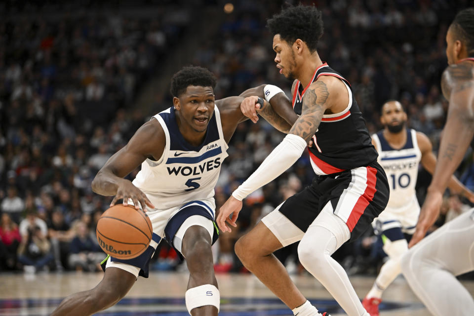 Minnesota Timberwolves guard Anthony Edwards, left, drives against Portland Trail Blazers guard Anfernee Simons during the first half of an NBA basketball game Friday, Jan. 12, 2024, in Minneapolis. (AP Photo/Craig Lassig)