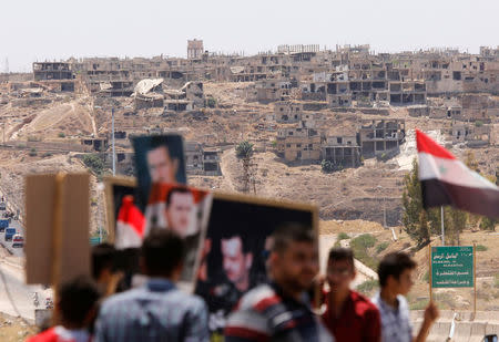 People celebrate the re-opening of the road between Homs and Hama in Talbisi, Syria, June 6, 2018. REUTERS/Omar Sanadiki