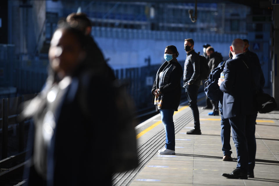 Commuters stand apart as they wait for a train at Canning Town underground station in London, after the announcement of plans to bring the country out of lockdown.