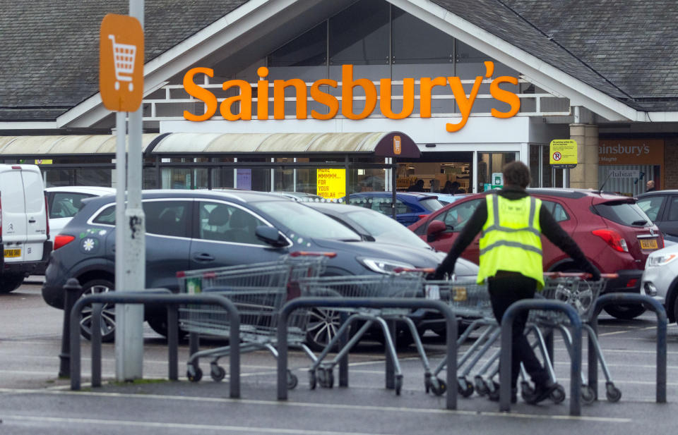 A sign above the entrance to a J Sainsbury Plc supermarket in Basildon, U.K.