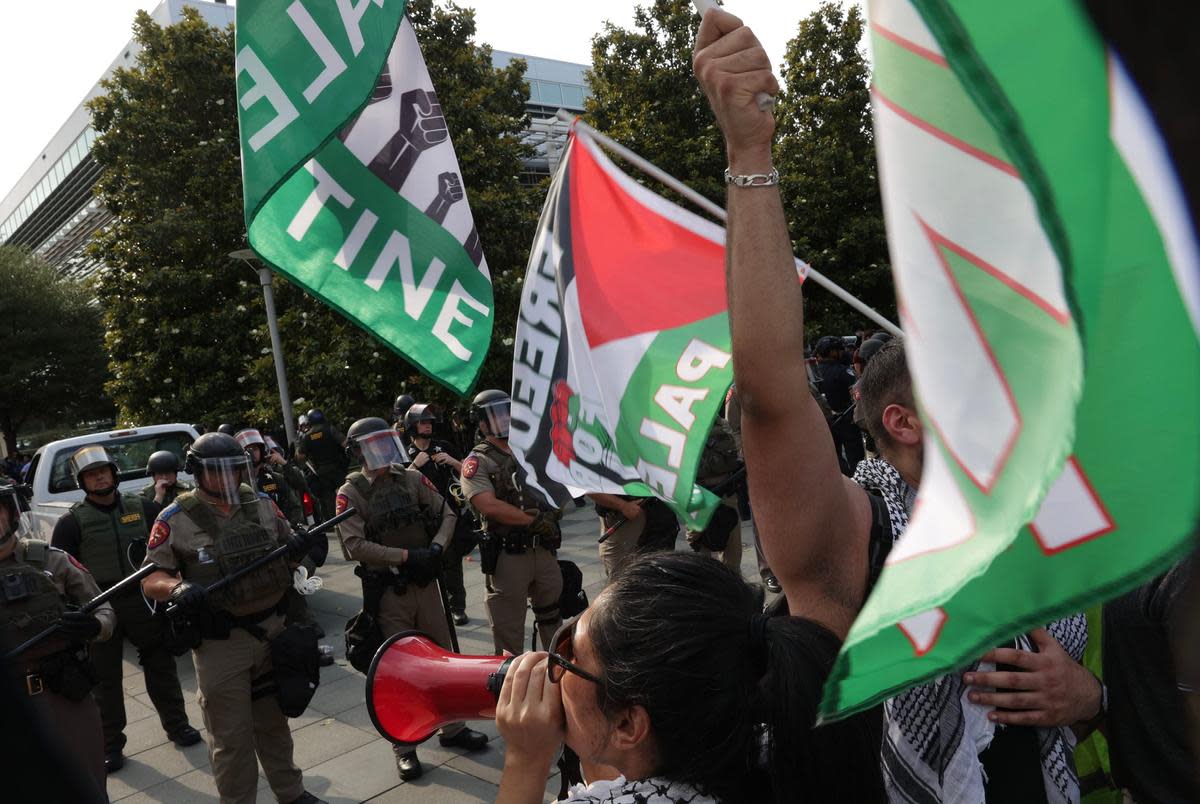 Protesters chant as DPS officers look on at the University of Texas at Dallas on Wednesday, May 1, 2024. Pro-Palestinian demonstrators set up an encampment on the campus before dawn. At about 4 p.m., DPS and other police officers showed up and tore down the encampment and arrested several people.