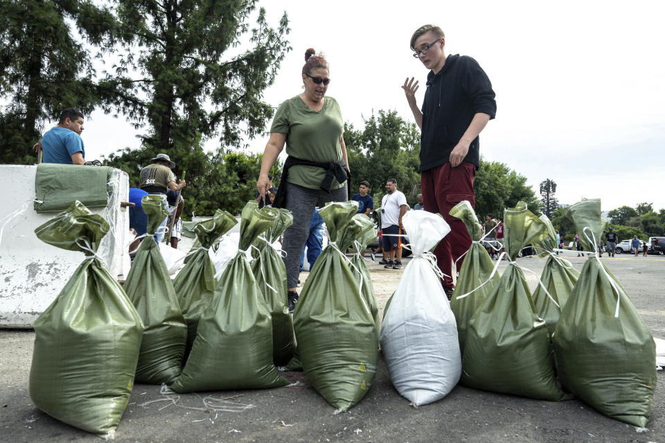 Rebecca Glaser, left, and her son Jaden Fitzpatrick, 16, prepare to load sandbags at Wildwood Park in San Bernardino, Ca., on Saturday, Aug. 19, 2023, as residents make preparations for the arrival of Hurricane Hilary. (Watchara Phomicinda/The Orange County Register via AP)