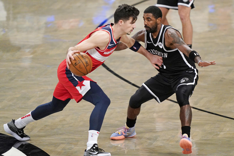 Brooklyn Nets guard Kyrie Irving (11) defends Washington Wizards rookie forward Deni Avdija (9) as Avdija drives toward the basket.