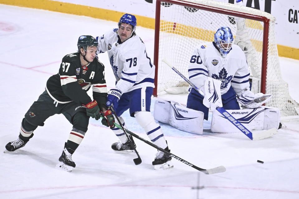 Minnesota's Kirill Kaprizov, left, Toronto's TJ Brodie, center, and Toronto's goalkeeper Joseph Woll in action during the NHL Global Series Sweden ice hockey match between Toronto Maple Leafs and Minnesota Wild at Avicii Arena in Stockholm, Sweden, Sunday, Nov. 19, 2023.(Claudio Bresciani/TT via AP)