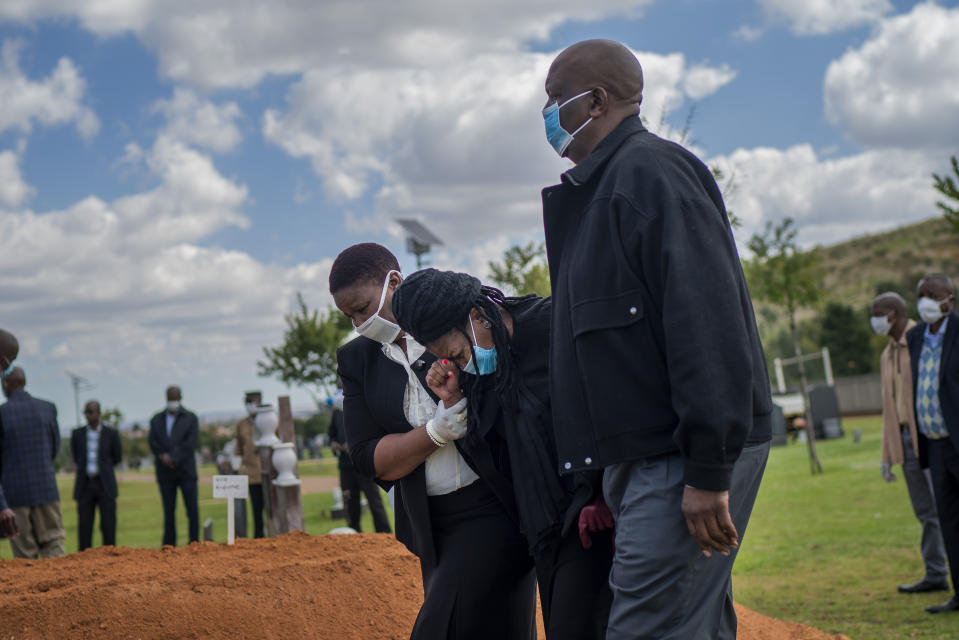 Parientes lloran la muerte de Benedict Somi Vilakasi, víctima del coronavirus, en un cementerio de Johannesburgo el 16 de abril del 2020. Con frecuencia la gente ignora las reglas del distanciamiento social en Sudáfrica durante la pandemia. (AP Photo/Jerome Delay)