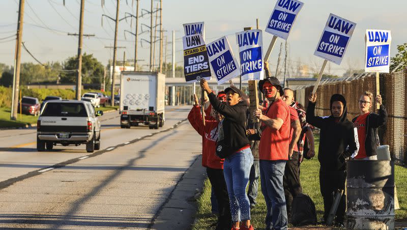 United Auto Workers, including Joseph Burch, wearing a mask, hold signs while on strike Friday, Sept. 15, 2023, at the Stellantis Toledo Assembly Complex in Toledo, Ohio.