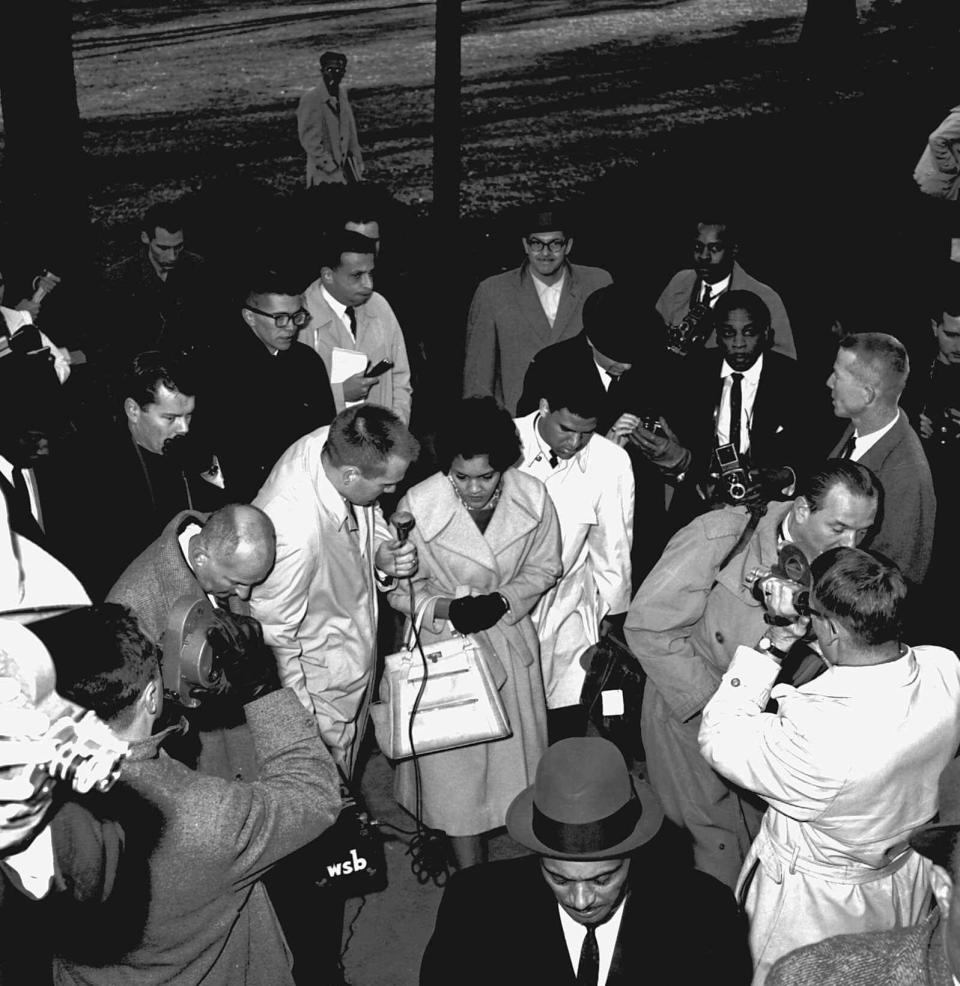 Charlayne Hunter, 18, and Hamilton Holmes, 19, center, have both been admitted to the University of Georgia under federal court order, are surrounded by newsmen as they arrive on the university campus in Athens, Ga., on Jan. 9, 1961. 