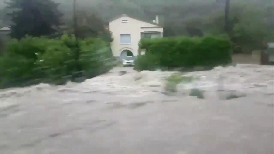 A home appears cut off as a torrent of water rushes past, in Saint Ambroix, France, Thursday Aug. 9, 2018. Heavy rain has caused flash flooding, transforming rivers and streams into torrents, the interior minister Gerard Collomb said on Thursday. (Loic Spadafora via AP)