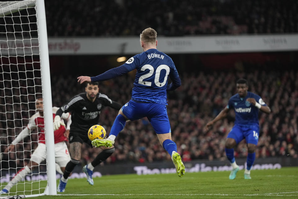 West Ham's Jarrod Bowen, center, keeps the ball in play in front of the goal during the English Premier League soccer match between Arsenal and West Ham at Emirates stadium in London, England, Thursday, Dec. 28, 2023. (AP Photo/Alastair Grant)