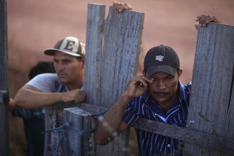 Worker Alves Borges de Nascimento (R) reacts as he watches agents of Brazil's Institute for the Environment and Renewable Natural Resources, or IBAMA, and a group of environmental police officers occupy the illegal sawmill where he was employed during a sting operation against sawmills, log haulers and loggers who trade in illegally extracted wood from the Alto Guama River indigenous reserve in Nova Esperanca do Piriau, Para state, September 25, 2013. Picture taken September 25, 2013. To match Special Report BRAZIL-DEFOREST/ REUTERS/Ricardo Moraes (BRAZIL - Tags: ENVIRONMENT CRIME LAW POLITICS BUSINESS EMPLOYMENT)