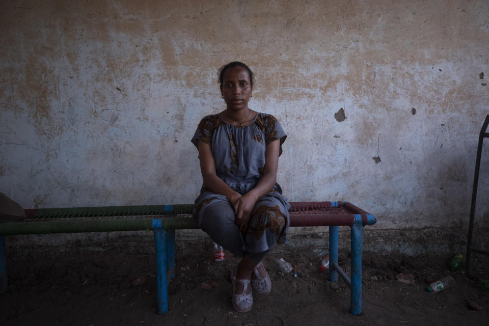 Elsa Tesfa Berhe, 26, center, a reproductive health official from Adwa, sits on a bench hours after arriving from Humera to Hamdayet, eastern Sudan, near the border with Ethiopia, on March 15, 2021. Reusing gloves and rationing water, Berhe treated women secretly after Eritrean soldiers swept through health centers, looting even the beds and telling patients to leave. As she snuck out to deliver babies and treat the wounded, she saw people trying to bury bodies at the risk of being shot, or pouring alcohol on corpses in an attempt to hide the smell. (AP Photo/Nariman El-Mofty)